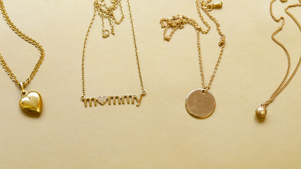 Image: 4 gold necklaces with different chain styles and pendants.
