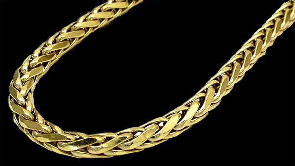 Image: Gold wheat chain against a black background.